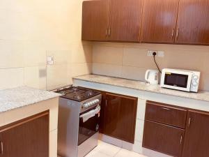 a kitchen with a stove and a microwave at Star Emirates Inn Hotel Salalah in Salalah +18 photos