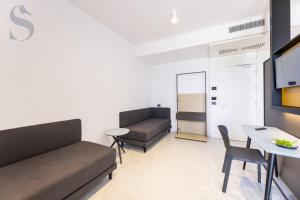 a living room with a couch and a table at Sud Hotel Pulsano in Pulsano