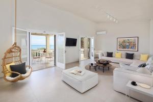un soggiorno bianco con divano e sedia di Ionian Garden Villas - Villa Pietra a Benitses