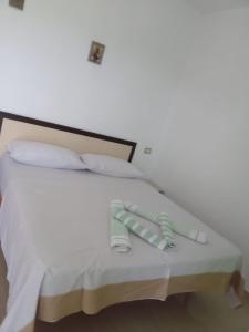 a bed with white sheets and pillows at Hotel PRINC in Velipojë