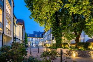 a city street with buildings and trees at night at GDA Hotel Schwiecheldthaus in Goslar