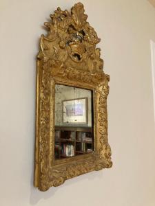 an ornate gold mirror hanging on a wall at Pineapple House, Spacious 1st Floor Apartment! City Center! 96 Walk Score! FREE parking! in Denver