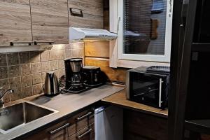 a kitchen with a sink and a microwave at Luxury Aurora glass Igloo, hot tub & sauna cottage in Rovaniemi