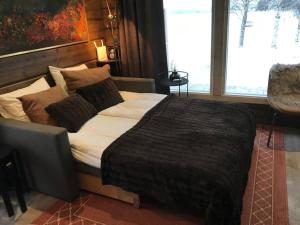 a bedroom with a large bed and a large window at Luxury Aurora glass Igloo, hot tub & sauna cottage in Rovaniemi
