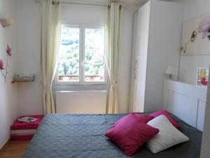 a bedroom with a bed with a large window at L'Esquerade in Castillon-de-Larboust