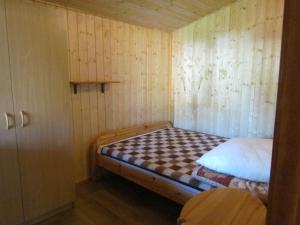 Habitación pequeña con cama en una pared de madera. en OW ZŁOTA PLAŻA, en Mielno