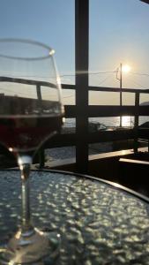a glass of wine sitting on a table with a view of the ocean at Anemos Pelion Seaview in Kala Nera