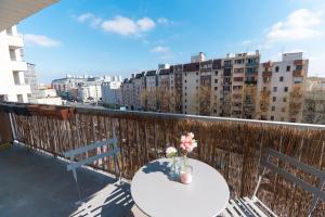 a table with flowers on a balcony with buildings at Le Citadin-T1-28m2-Pte Paris M7 in Le Kremlin-Bicêtre