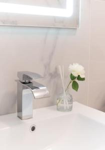 a white flower in a vase next to a sink at Le Citadin-T1-28m2-Pte Paris M7 in Le Kremlin-Bicêtre