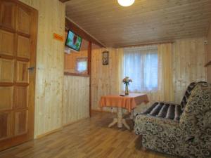 een woonkamer met een tafel, een stoel en een deur bij OW ZŁOTA PLAŻA in Mielno