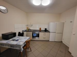 a kitchen with white appliances and a table in it at Jelinski Beherbergungsstätten Ostingersleben in Ostingersleben