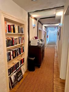 einen Flur mit Bücherregalen und einen Schreibtisch in einem Zimmer in der Unterkunft Hotel Pemü in Arnsberg