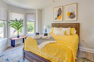Un dormitorio con una gran cama amarilla con ventanas. en Lynchburg Rental with Deck Near Downtown!, en Lynchburg