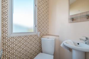 uma casa de banho com um WC, um lavatório e uma janela em 3 Bed Static Caravan-Seton Sands em Longniddry