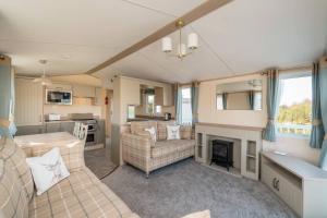 a living room with a couch and a fireplace at 3 Bed Static Caravan-Seton Sands in Longniddry