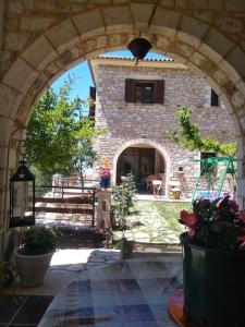een stenen gebouw met een boog op een binnenplaats bij Βίλλα Τρία Ποτάμια καταρράχτες ΝΈΔΑ 