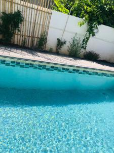 una piscina blu accanto a una recinzione di legno di Proche Avignon au calme a Les Angles Gard