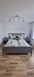 ein Schlafzimmer mit einem großen Bett mit zwei Nachttischen in der Unterkunft Ferienwohnung "Gartenblick" Wolzhausen in Breidenbach