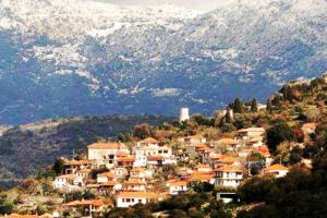 een klein stadje op een heuvel met bergen op de achtergrond bij Βίλλα Τρία Ποτάμια καταρράχτες ΝΈΔΑ 