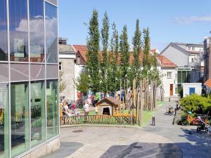a city street with a building and a playground at Cozee Central Apartments in Stavanger