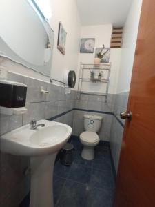 a bathroom with a sink and a toilet and a mirror at Departamento en Huancayo in Huancayo