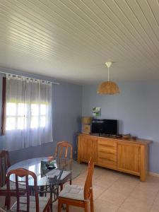 a living room with a table and chairs and a tv at LA CAZ TRANKIL in La Trinité