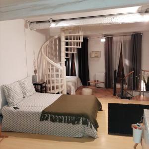 a bedroom with a white bed and a couch at Le Triplex Pézenas in Pézenas
