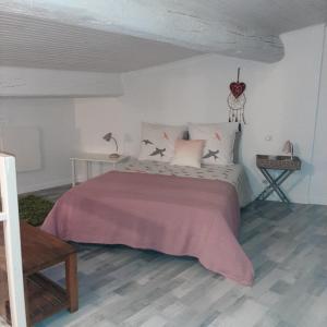 a bedroom with a large bed with pink sheets and pillows at Le Triplex Pézenas in Pézenas