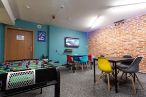 ein Raum mit einem Tischfußballtisch und Stühlen in der Unterkunft Moon Hostel Gdańsk in Danzig