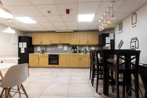 eine Küche mit Holzschränken, einem Tisch und Stühlen in der Unterkunft Moon Hostel Gdańsk in Danzig