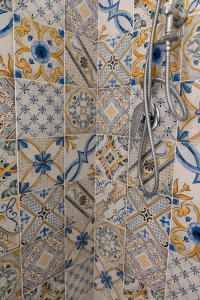 La salle de bains est revêtue de carrelage bleu et blanc. dans l'établissement Casa Rubina, à Capri