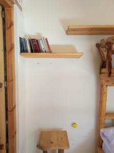 een kamer met een plank met boeken aan de muur bij Kato Symi house in Káto Sími