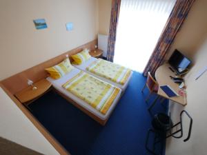 Kleines Zimmer mit 2 Betten und einem Schreibtisch. in der Unterkunft TM Hotel Westfalen in Lünen