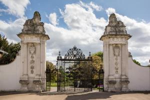 uma entrada para um edifício branco com um portão em The Lion Gate Mews em Kingston upon Thames