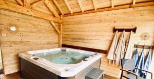 uma banheira de hidromassagem num chalé de madeira em Le Chalet de Castille - chalet pyrénéen grand confort - spa em Beaucens