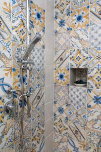 a bathroom with a shower with blue and white tiles at Casa Rubina in Capri