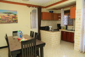 a kitchen with a table and a dining room at Artistic Oasis 2Bedrm Apartment in Buwate