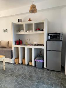 a kitchen with a counter with a sink and a microwave at Appartement 1 Riad Dar Samar in Tamraght Ouzdar