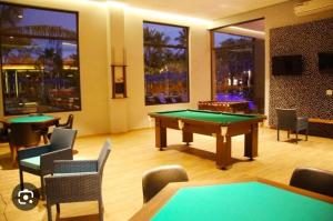 una sala giochi con tavolo da biliardo e sedie di Hot Beach Suites Olímpia a Olímpia