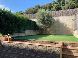 een tuin met een steunmuur en een groen gazon bij An excellent double room close to the UDG University in Girona