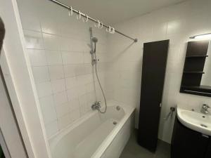 y baño con bañera y lavamanos. en Duplex très agréable et très calme, en Bruselas