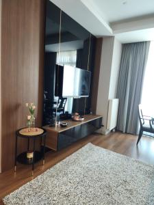 ein Wohnzimmer mit einem TV und einem Tisch mit einem Teppich in der Unterkunft Polat tower 1 in Istanbul