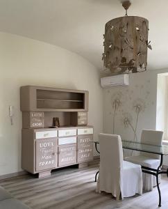 ein Esszimmer mit einem Glastisch und einem Kronleuchter in der Unterkunft Novecento Charming Room in Avigliana