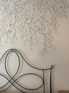 a chair in front of a wall with a tree mural at Novecento Charming Room in Avigliana