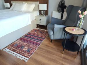 ein Schlafzimmer mit einem Bett, einem Stuhl und einem Teppich in der Unterkunft Polat tower 1 in Istanbul