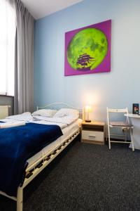1 dormitorio con 1 cama y una pintura en la pared en Moon Hostel Gdańsk, en Gdansk