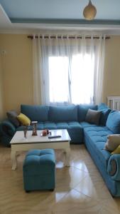 a living room with a blue couch and a table at Guesthouse Isolde in Vlorë