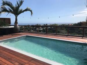 a pool on a deck with a view of the ocean at Cocooning Tropic Studio avec Jacuzzi privatif in Saint-Louis