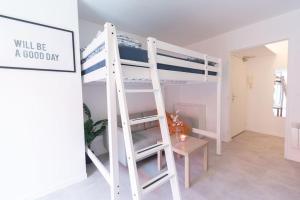 ル・クレムラン・ビセートルにあるLe Studieux-T1-30m2-Pte Paris M7の白い二段ベッド(はしご付)が備わる客室です。