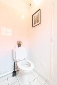 une salle de bains blanche avec des toilettes et une photo sur le mur. dans l'établissement Le Studieux-T1-30m2-Pte Paris M7, au Kremlin-Bicêtre